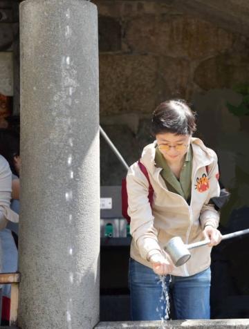 adrien cleanses their hands at a temple